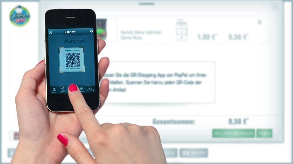 Ruka drží telefon a snímá QR kód