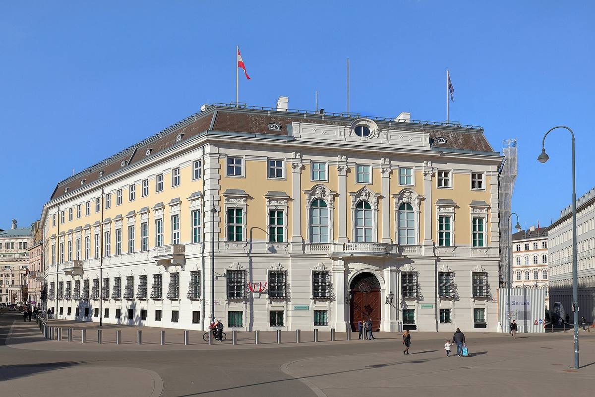 Bílá barokní budova úřadu spolkového kancléře ve Vídni s řadou oken a vstupním portálem