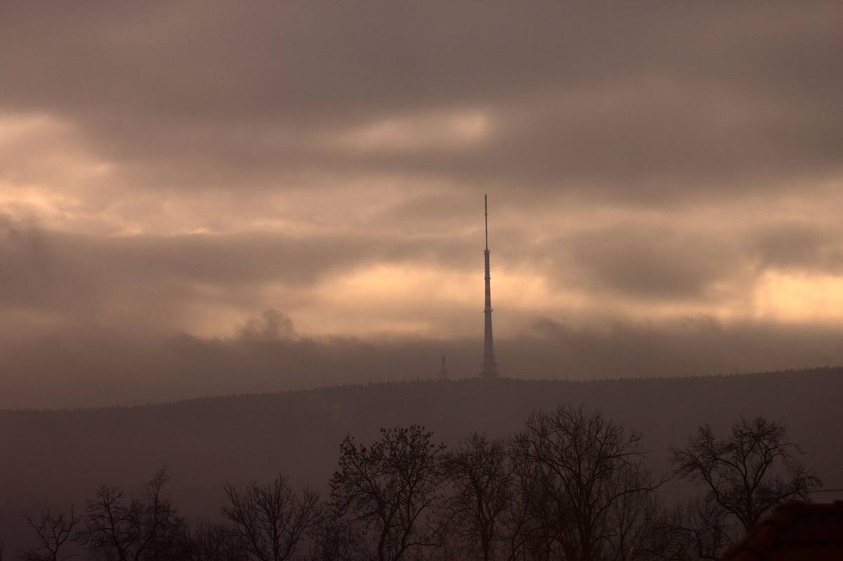 Televizní vysílač Cukrák jižně od Prahy nad krajinou zahalenou do nízkých mraků