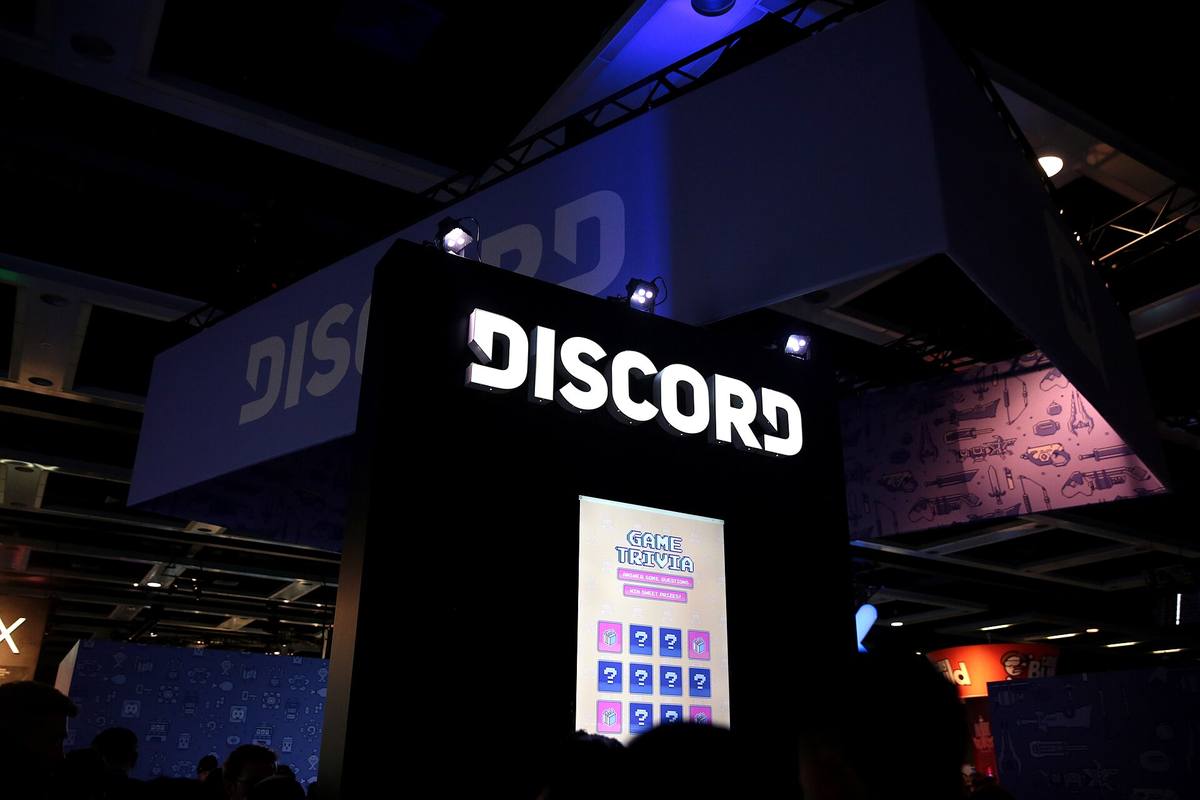 Svítící nápis Discord na stánku ve výstavní hale, pod ním obrazovka s herním kvízem
