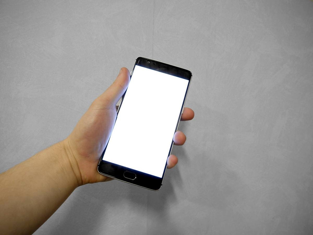 Ruka držící chytrý telefon s prázdnou obrazovkou
