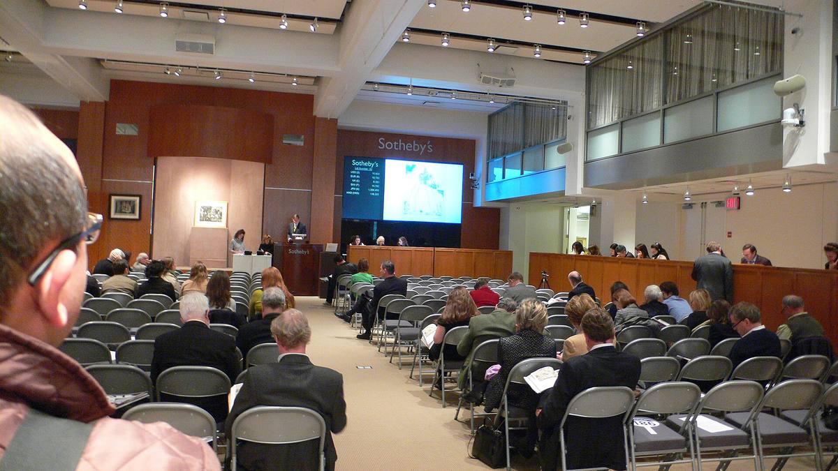Dražební sál aukčního domu Sotheby's s řadami sedadel a pultem pro zaměstnance