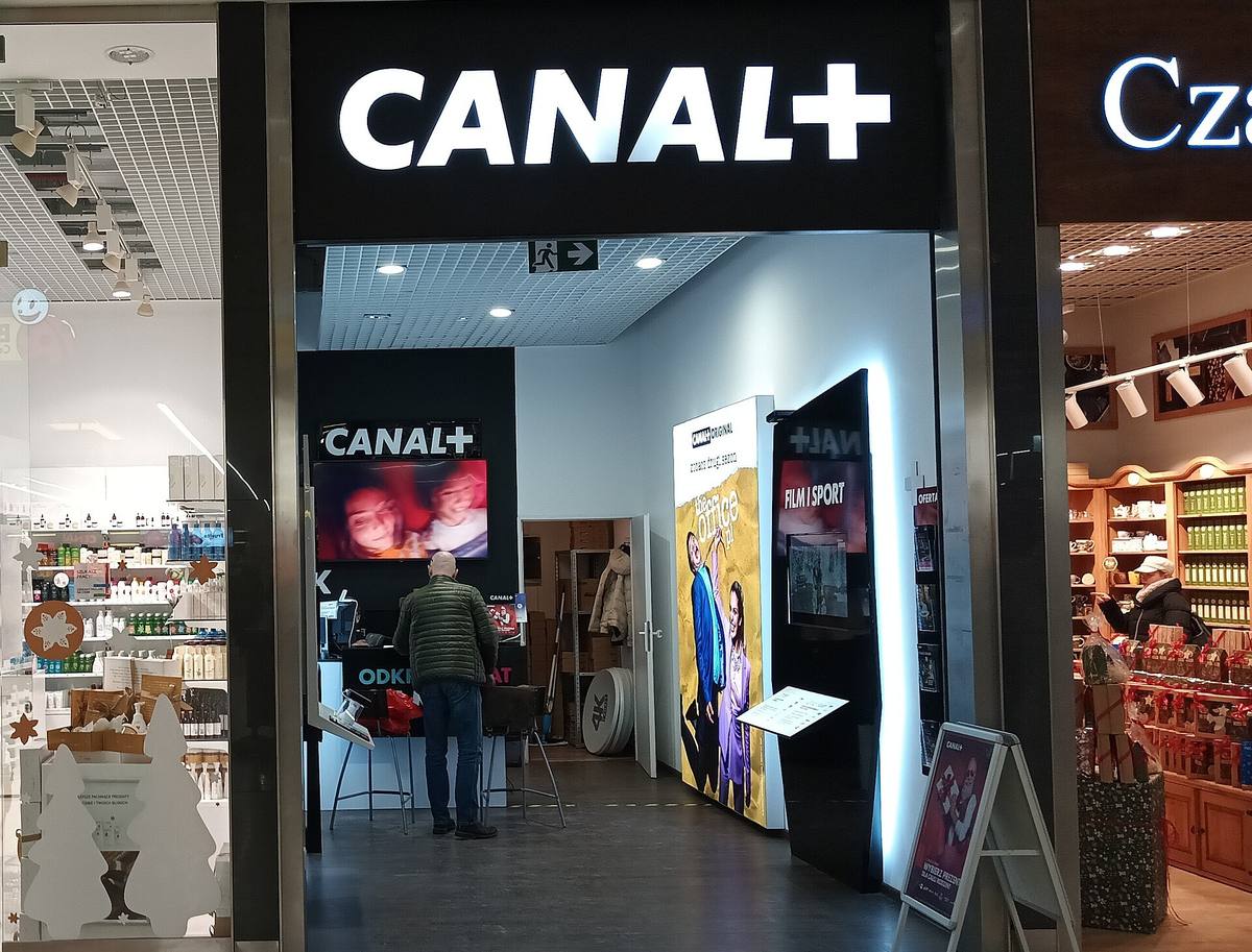 Výloha prodejny Canal+ s logem nad vchodem