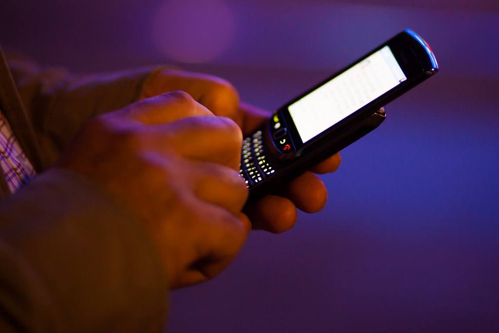 Ruce píšou zprávu na mobilním telefonu